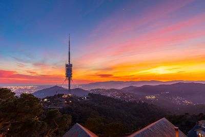 Sunset in barcelona, spain with the collserola tower in the background