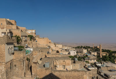 Buildings in town against clear blue sky