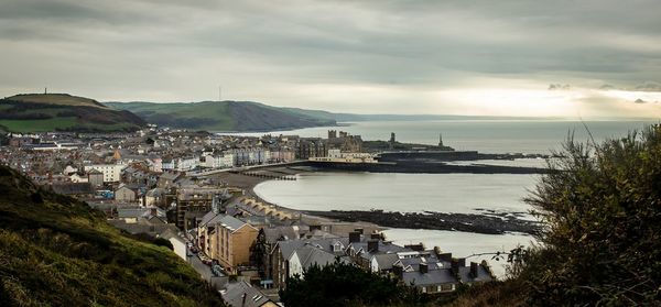 Panoramic view of town by sea against sky