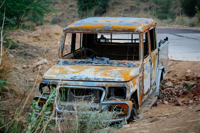 Old abandoned car on field