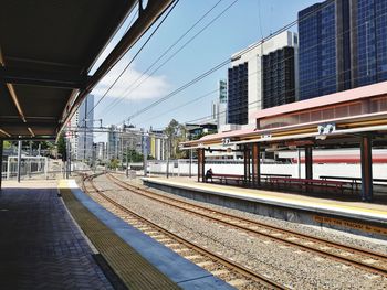 Railroad station in city against sky