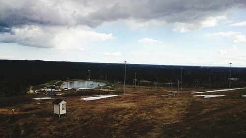 Rural landscape against cloudy sky