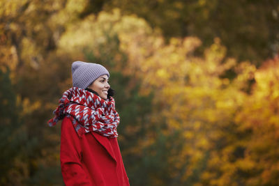 Side view of woman standing against trees