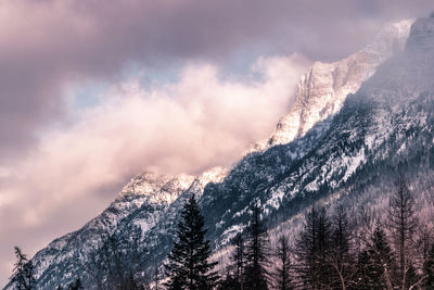 Low angle view of snow covered mountains against sky