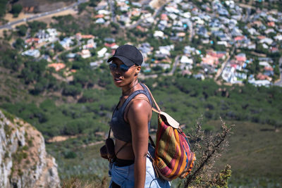 Portrait of woman in sunglasses standing on hill