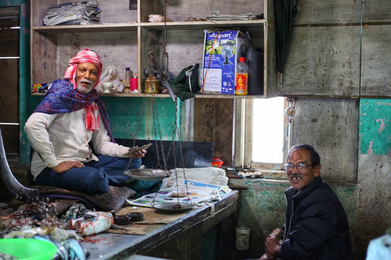 PORTRAIT OF FRIENDS SITTING ON MARKET