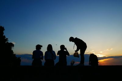 Silhouette people while waiting see sunset sky at the beach