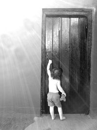 Boy with arms raised against sky