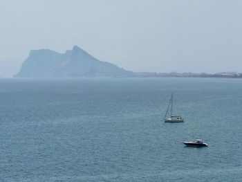 Sailboats in sea against clear sky