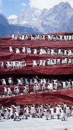 Group of people on snowcapped mountains against sky