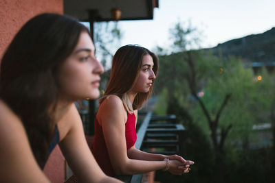 Lesbian couple looking away in balcony