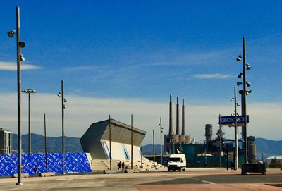 Road by pier against blue sky