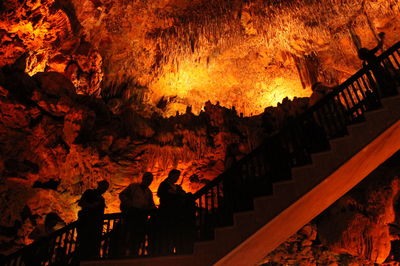 People standing by railing at night