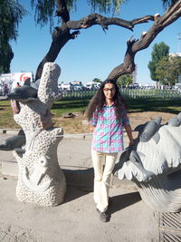 Portrait of smiling young woman sitting on tree