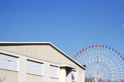 Low angle view of ferris wheel against clear sky