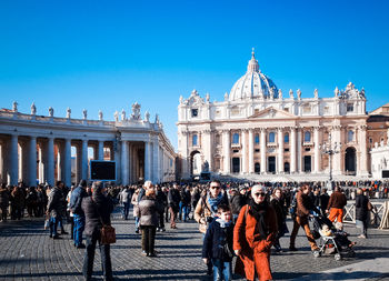 People at st peters square in city against clear blue sky