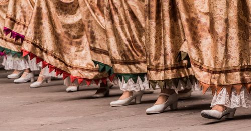 Low section of women in traditional clothing dancing outdoors