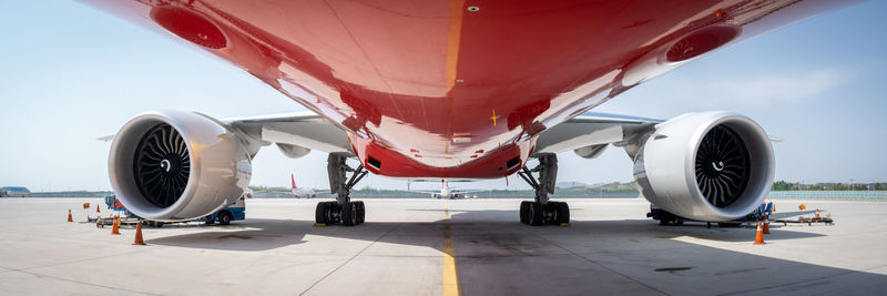 Airplane on airport runway against sky