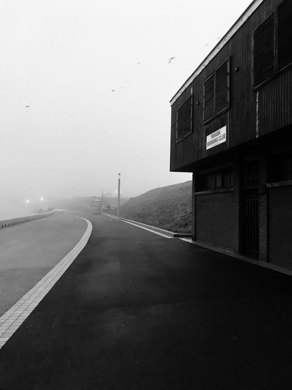 ROAD BY BUILDING AGAINST CLEAR SKY