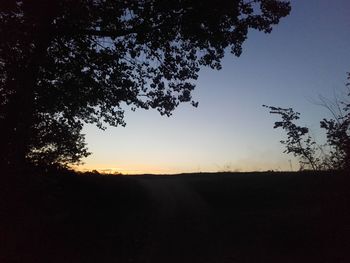 Scenic view of silhouette field against sky at sunset