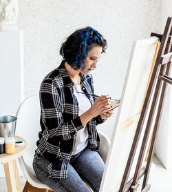 Creative woman artist painting a picture working in her studio