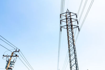 Low angle view of electricity pylon against clear sky