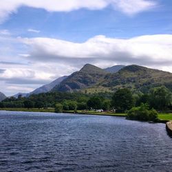 Scenic view of lake and mountains against cloudy sky