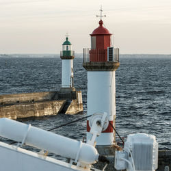 Lighthouse by sea against sky