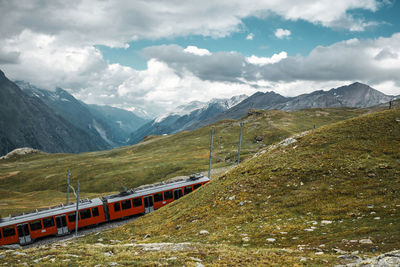 Railway and red train in gornergrat mountains. zermatt, swiss alps. adventure in switzerland.