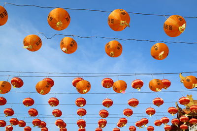 Low angle view of lanterns hanging against sky