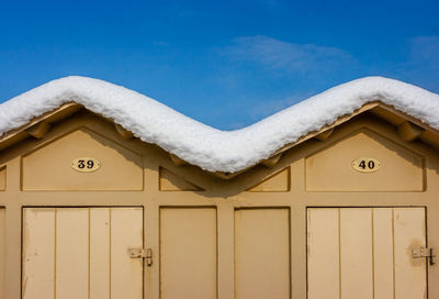 Close-up of snow covered building against sky