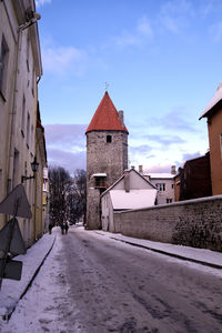 Road amidst buildings in city against sky