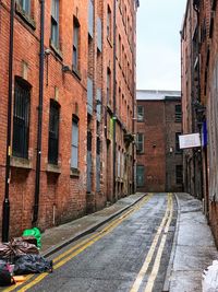 Empty road amidst buildings in city