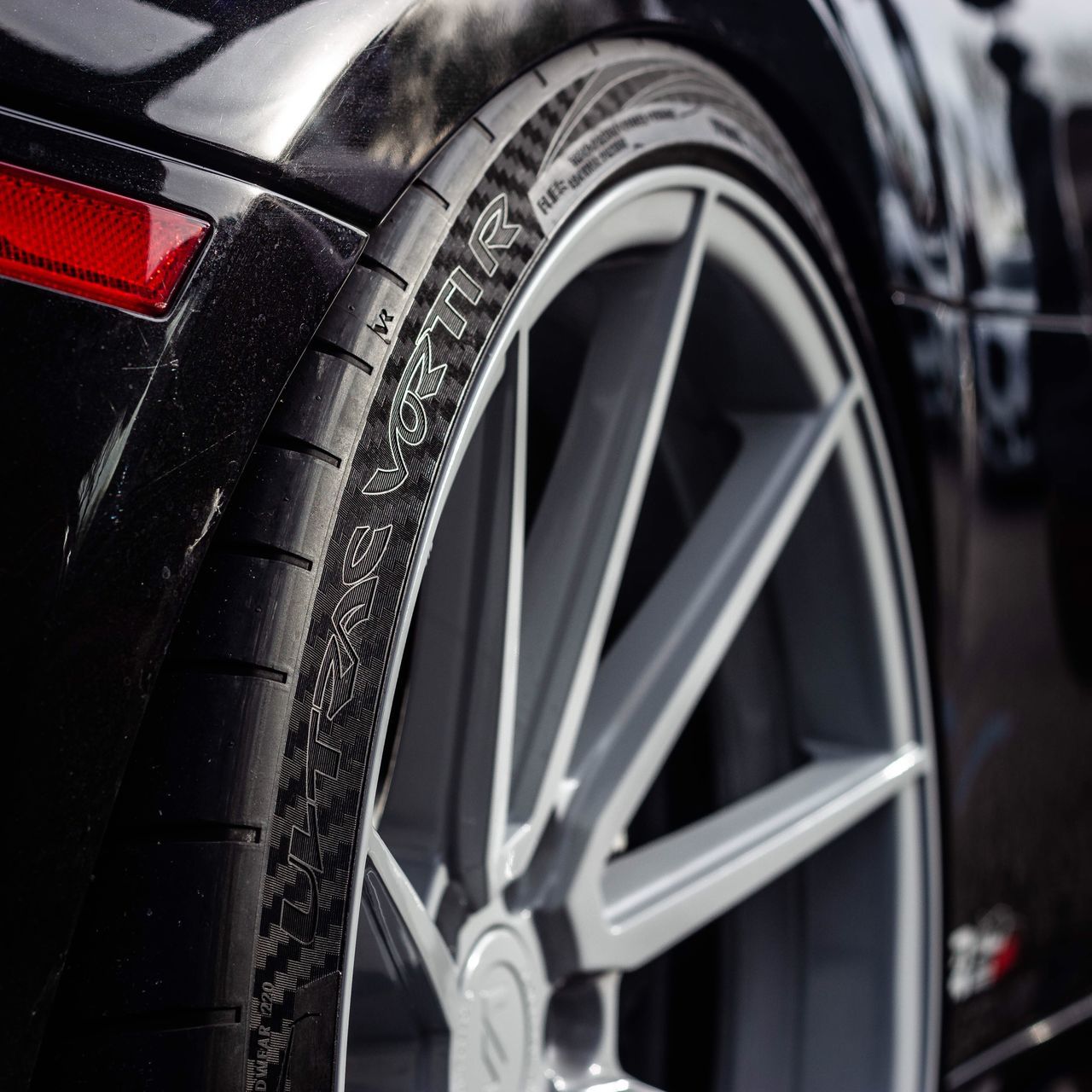 wheel, transportation, mode of transportation, tire, land vehicle, car, close-up, motor vehicle, metal, focus on foreground, no people, retro styled, vehicle part, day, spoke, outdoors, black color, selective focus, stationary