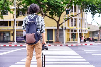 Rear view of man walking on street in city