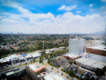 High angle view of cityscape against cloudy sky