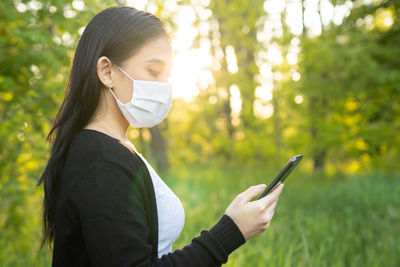Portrait of young woman using mobile phone outdoors