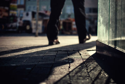 Low section of man walking on street