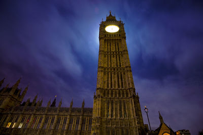 Low angle view of clock tower against sky at night