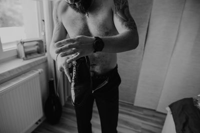 Midsection of man holding woman standing in corridor