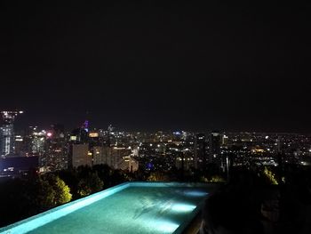 Illuminated cityscape against sky at night