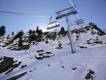 Low angle view of ski lift against sky during winter