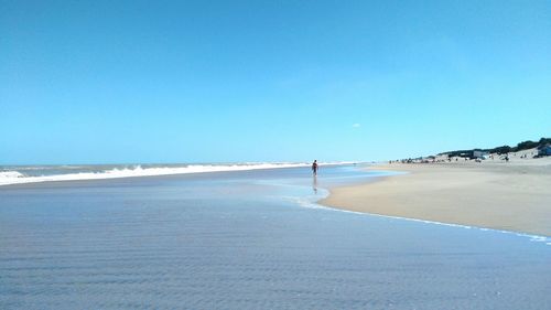 View of beach against clear blue sky