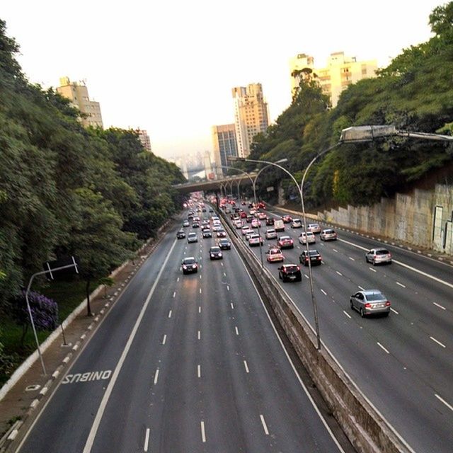 transportation, car, land vehicle, mode of transport, architecture, building exterior, built structure, city, road, traffic, tree, street, high angle view, road marking, on the move, clear sky, the way forward, city street, city life, travel