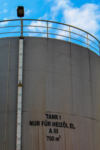 Low angle view of information sign against sky