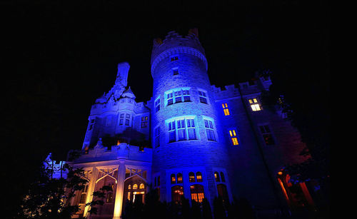 Low angle view of illuminated building against sky at night