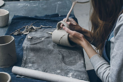 Midsection of woman making clay cup