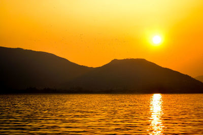 Scenic view of lake against orange sky