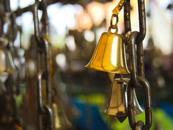 Close-up of bell hanging from metallic chain