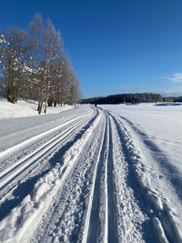 Snow covered landscape against blue sky